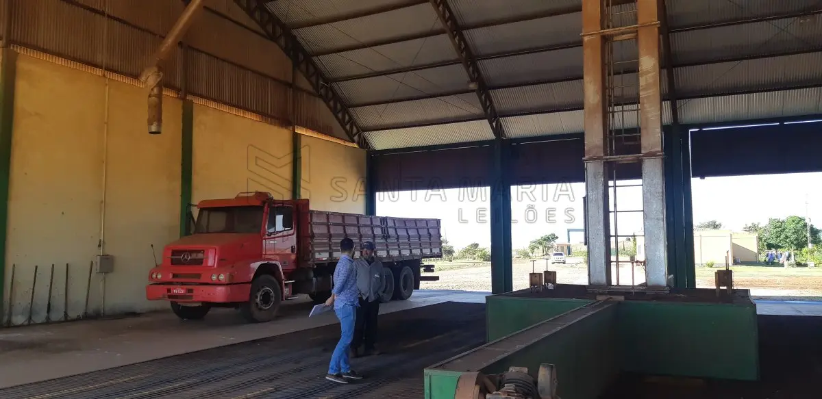 LOTE 004 - Um pavilhão de alvenaria, com telhas metálicas, de aprox. 500m², com 4 moegas para recebimento de grãos, um elevador e espaço para armazenagem, além de área para funcionários e, uma construção de alvenaria de aprox.15m² para coleta de amostra de cereais. Prédios construídos de alvenaria com 2 apartamentos de 2 dormitórios, cozinha, salão, vestiário, além do escritório destinado ao atendimento da empresa, com aprox. 250m², divididos em um único pavimento, coberto com telhas metálicas; ao lado da mesma localiza-se uma balança rodoviária, de marca Saturno, de aprox. 70m²; O lote ainda apresenta uma sala com aprox. 6m² de alvenaria que abriga um transformador, no lugar denominado Ivaí, na localidade de Cinamomo.