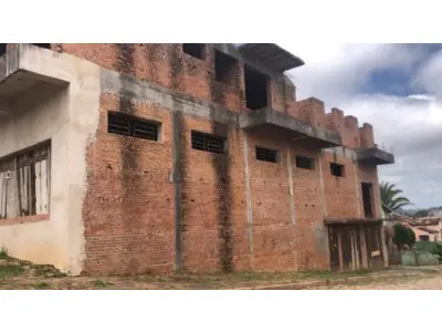 LOTE 001 - 50% (cinquenta por cento) do imóvel localizado na rua Clemenciano Barnasque nº 1101 em São Sepé/RS, sendo: Terreno com 418,88m² de esquina em declive localizado na junção das ruas Independência e Clemenciano Barnasque, possui uma construção inacabada e, conforme avaliação feita pelo perito: No subsolo, garagens, no primeiro pavimento sala comercial e no segundo pavimento apartamentos. A área construída total do prédio foi aferida in loco em torno de 942m². Matriculado sob n°81 do CRI de São Sepé/RS.