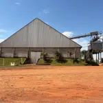 CENTRO DE RECEBIMENTO, SECAGEM E ARMAZENAGEM DE GRÃOS NO DISTRITO DE COIMBRA, COM CONSTRUÇÃO DE ALVENARIA DESTINADA PARA ESCRITÓRIO E ATENDIMENTO COM APROX. 150M². AO LADO, UM GALPÃO PARA RECEBIMENTO DE GRÃOS COM 4 MOEGAS, UM GALPÃO PARA ARMAZENAGEM E ONDE ESTÁ LOCALIZADA A CALDEIRA DO SECADOR, SEPARADOR E ESTOQUE DE INSUMOS, DUAS BALANÇAS RODOVIÁRIAS DE APROXIMADAMENTE 70M² CADA UMA, E UM SILO HORIZONTAL DE CONCRETO PARA ARMAZENAGEM DE GRÃOS, COM CAPACIDADE PARA 200MIL SACOS, DEMAIS EQUIPAMENTOS E BENFEITORIAS (BENFEITORIAS NÃO AVERBADAS NA MATRÍCULA).