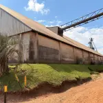 CENTRO DE RECEBIMENTO, SECAGEM E ARMAZENAGEM DE GRÃOS NO DISTRITO DE COIMBRA, COM CONSTRUÇÃO DE ALVENARIA DESTINADA PARA ESCRITÓRIO E ATENDIMENTO COM APROX. 150M². AO LADO, UM GALPÃO PARA RECEBIMENTO DE GRÃOS COM 4 MOEGAS, UM GALPÃO PARA ARMAZENAGEM E ONDE ESTÁ LOCALIZADA A CALDEIRA DO SECADOR, SEPARADOR E ESTOQUE DE INSUMOS, DUAS BALANÇAS RODOVIÁRIAS DE APROXIMADAMENTE 70M² CADA UMA, E UM SILO HORIZONTAL DE CONCRETO PARA ARMAZENAGEM DE GRÃOS, COM CAPACIDADE PARA 200MIL SACOS, DEMAIS EQUIPAMENTOS E BENFEITORIAS (BENFEITORIAS NÃO AVERBADAS NA MATRÍCULA).